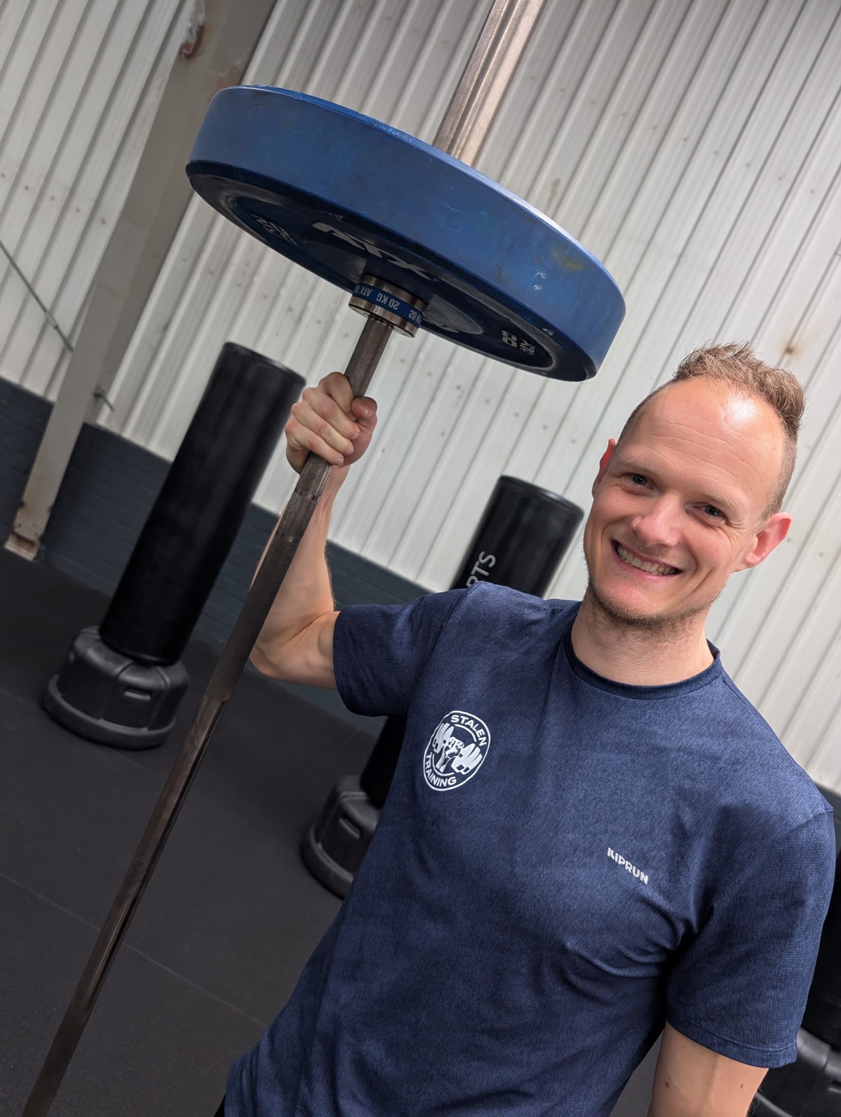Timothy Stalenhoef met een gewichtsschijf in de gym